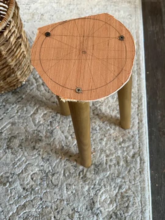 3 stool legs screwed into scrap wood with screws