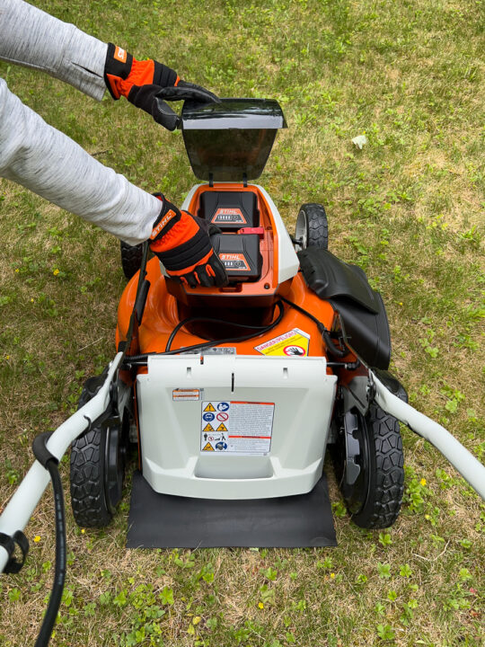 Stihl mower with batteries being inserted.