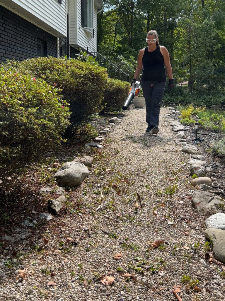 using a Stihl leaf blower on a sidewalk