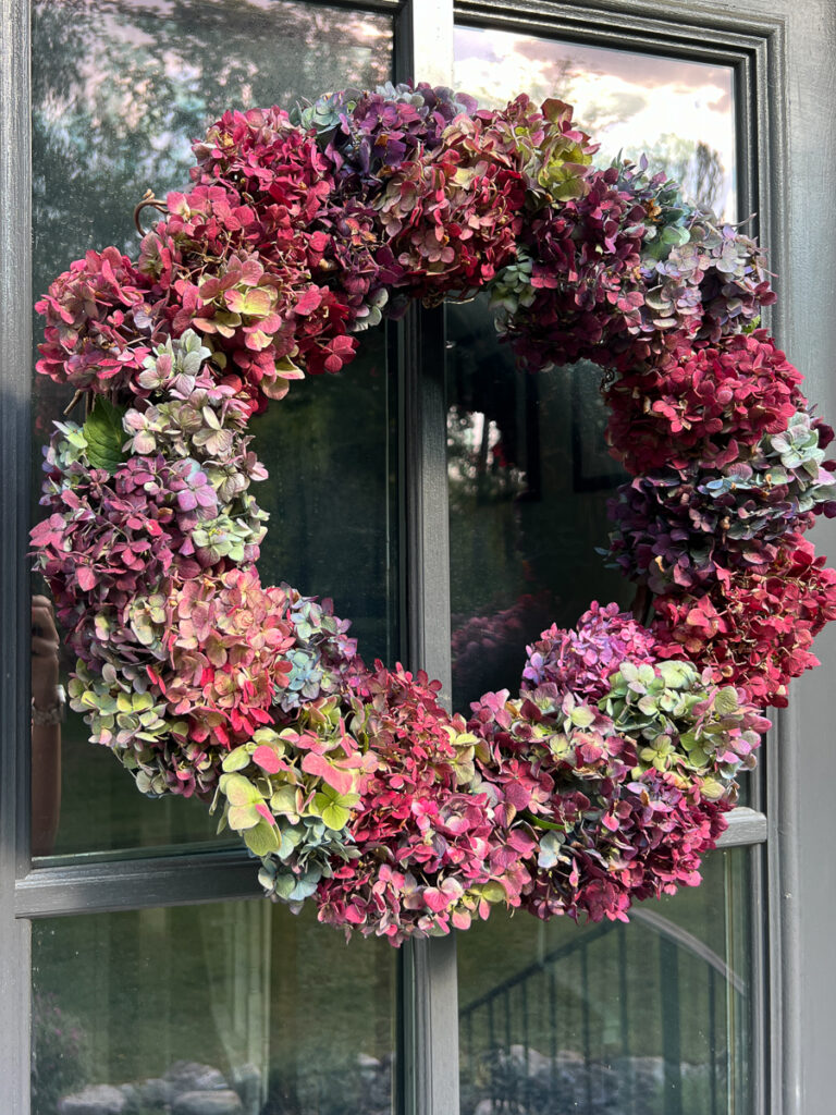 dried hydrangea wreath hanging on a door