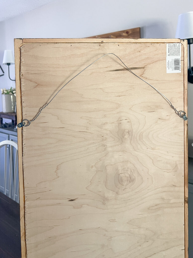 the back of a large driftwood art piece to hang using d rings and wire