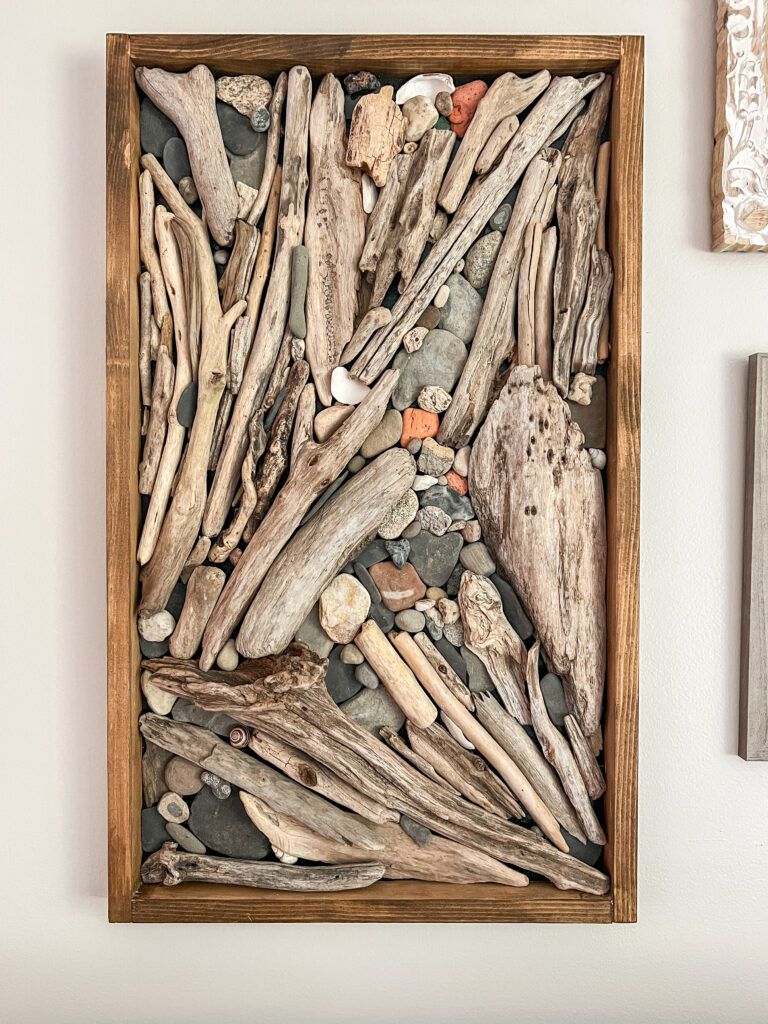 wall art made out of driftwood, stones and shells found at the lake.