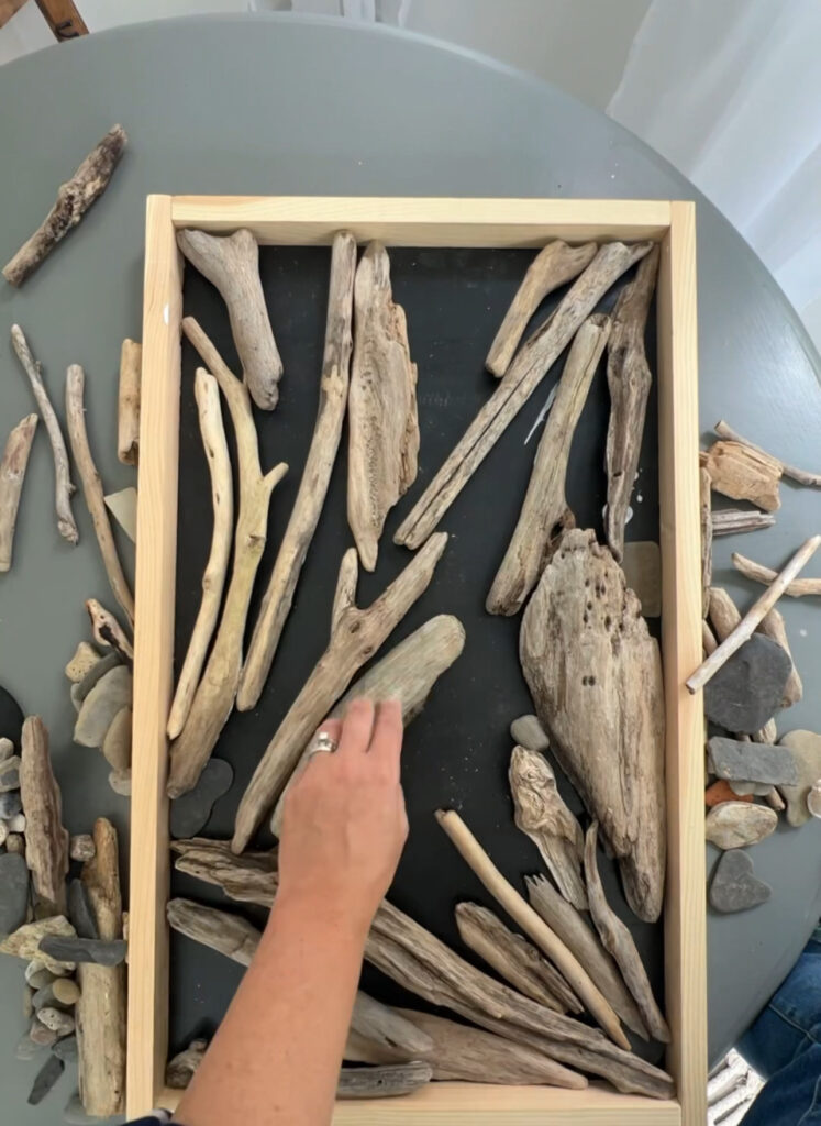 gluing pieces of driftwood to a board for art