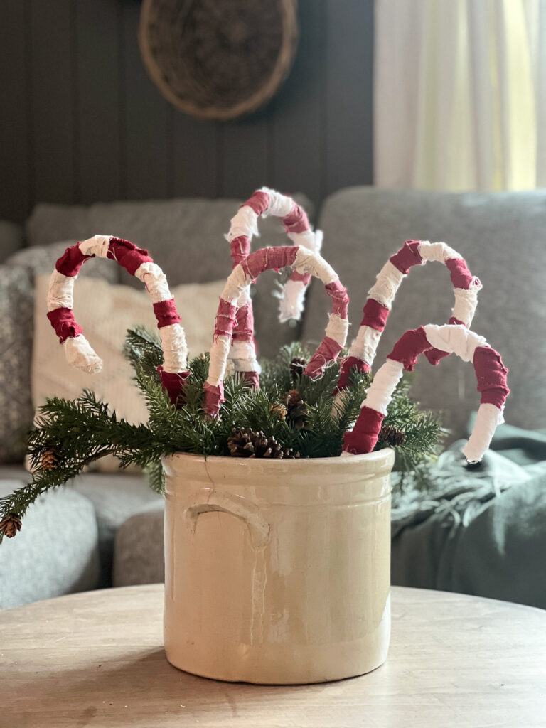 fabric homemade candy canes in a vintage crock with greenery