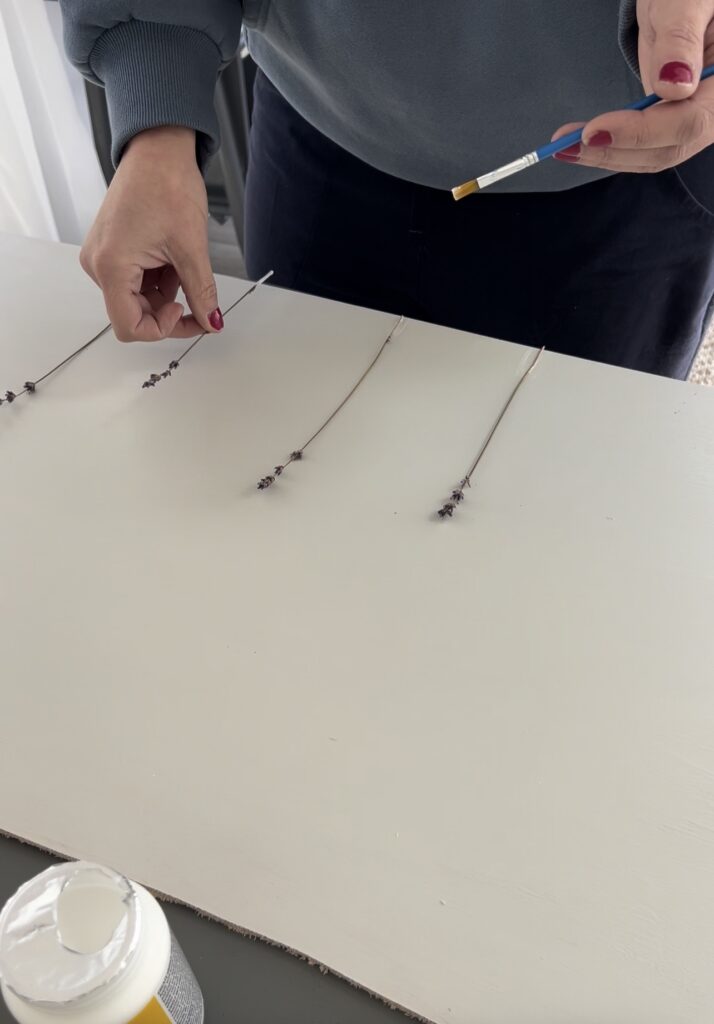 placing strands of lavender on a painted board